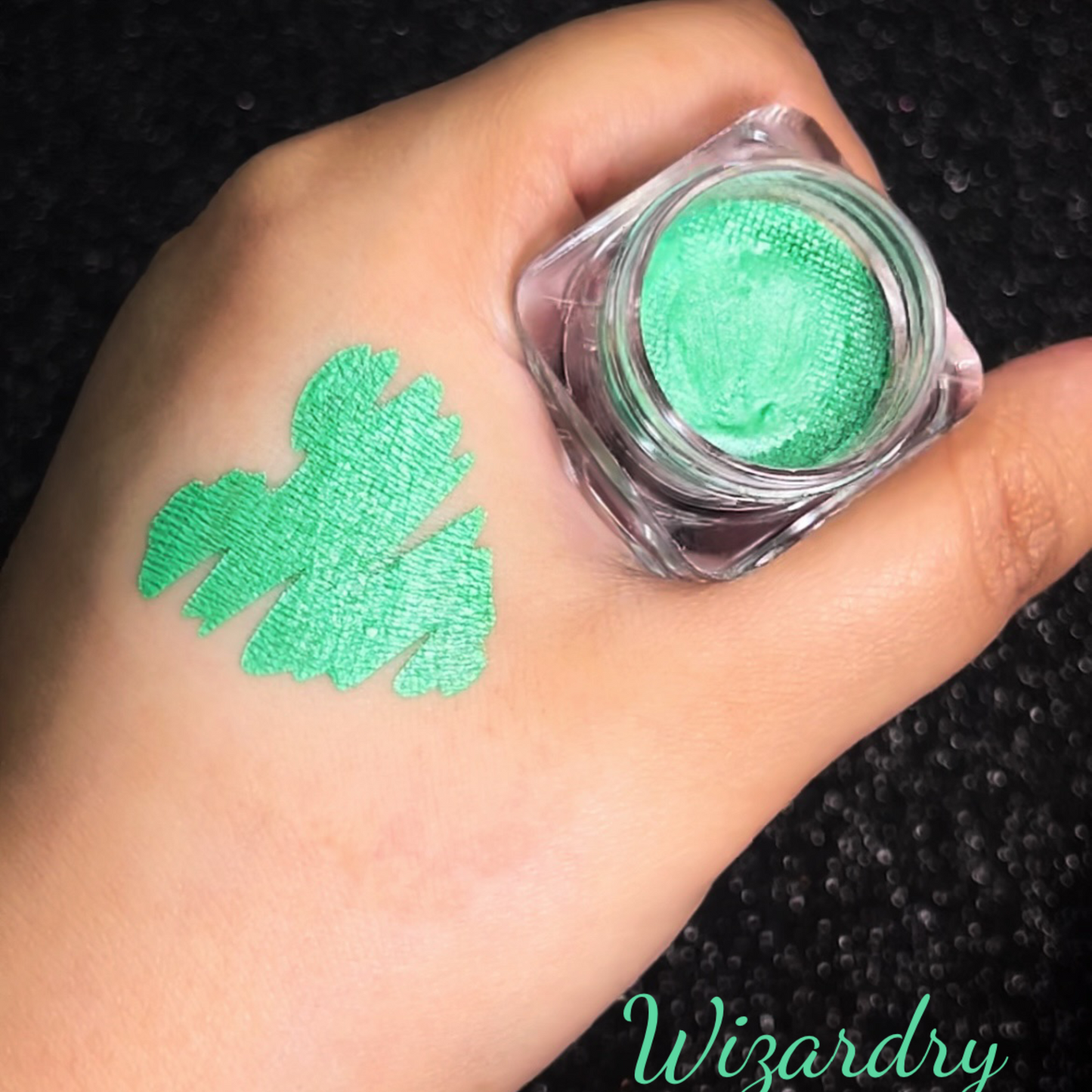 A shade swatch of Metallic water activated eyeliner In wizardry. A bright green metallic eyeliner